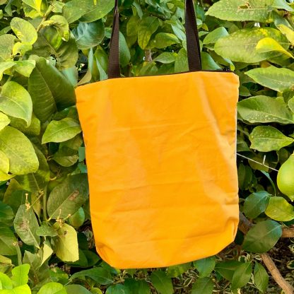 Totebag de algodón hecha a mano, con cierre de cremallera, con estampado artesanal de abejas y trasera de loneta amarilla (detrás).