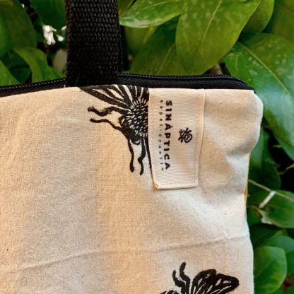 Detalle de totebag de algodón hecha a mano, con cierre de cremallera, con estampado artesanal de abejasy trasera de loneta amarilla.