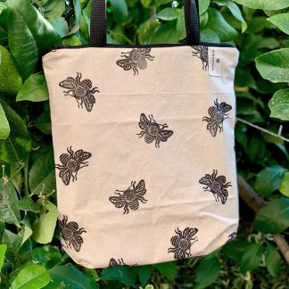 Totebag de algodón hecha a mano, con cierre de cremallera, con estampado artesanal de abejas y trasera de loneta amarilla.