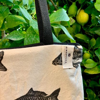 Totebag de algodón, con cierre de cremallera, con estampado artesanal de carpas de rio y trasera de loneta verde turquesa.